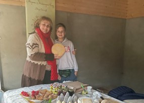 Zwei Frauen mit einem handwerklich verarbeiteten Käselaib