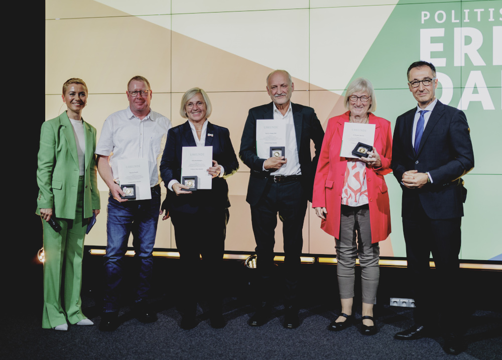 Gruppenfoto nach der Verleihung der Professor Niklas-Medaille: Bundesminister Cem Özdemir steht mit den vier Preisträgerinnen und Preisträgern und der Moderatorin auf der Bühne.