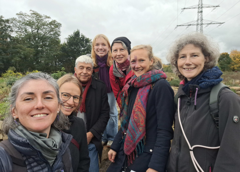 Mehrere Menschen lachen auf einem Gemüseacker in die Kamera