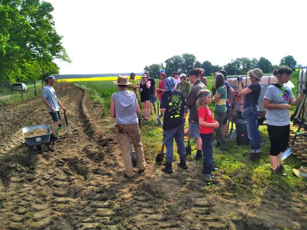 Eine Gruppe Menschen auf einem Acker