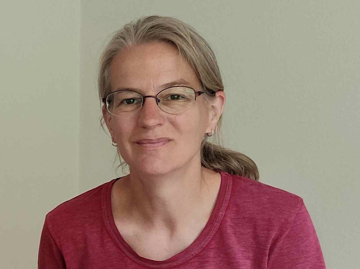 Eine blonde Frau lächelt in die Kamera