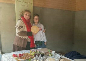 Zwei Frauen mit einem handwerklich verarbeiteten Käselaib