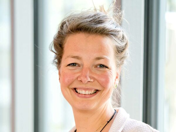 Eine blonde Frau lächelt in die Kamera