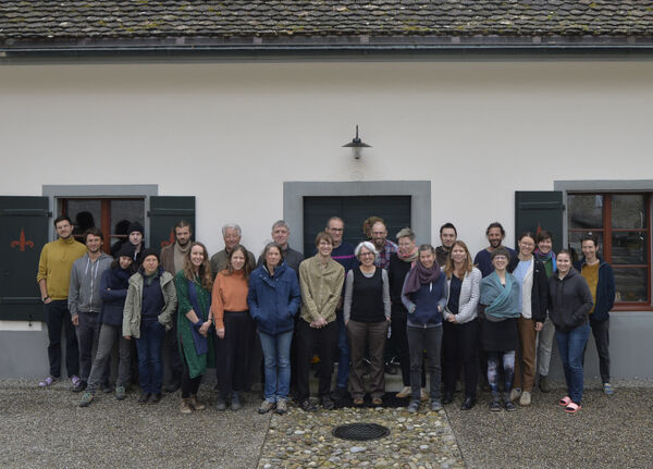 Eine Gruppe von über 20 Leuten steht vor einem alten Haus.