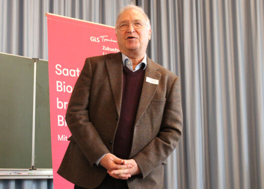 Ein älterer Herr berichtet auf der Bühne über seine Arbeit.