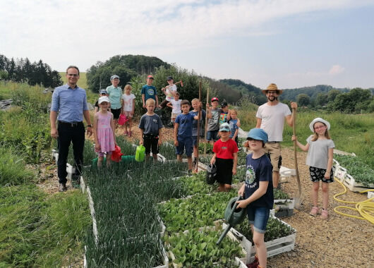 Gruppenbild auf dem Acker mit Kindern und zwei Erwachsenen