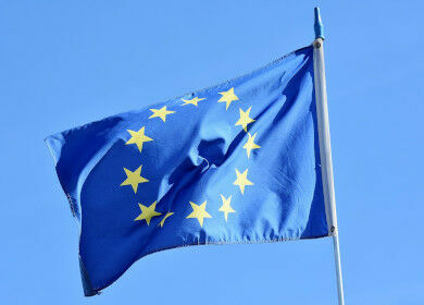 Eine wehende EU-Flagge (zwölf gelbe Sterne auf blauem Grund) 